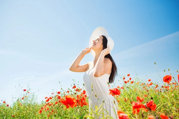 Jeune femme souriante en chapeau de paille sur champ de pavot — Photo