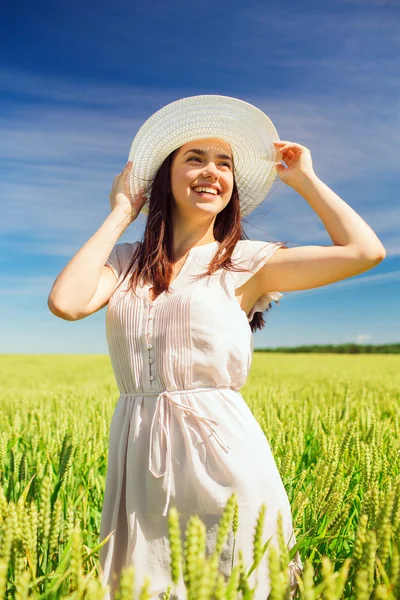 Jeune femme souriante en chapeau de paille sur le champ de céréales — Photo