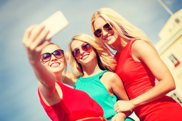 Chicas sonrientes tomando fotos con cámara de teléfono inteligente — Foto de Stock