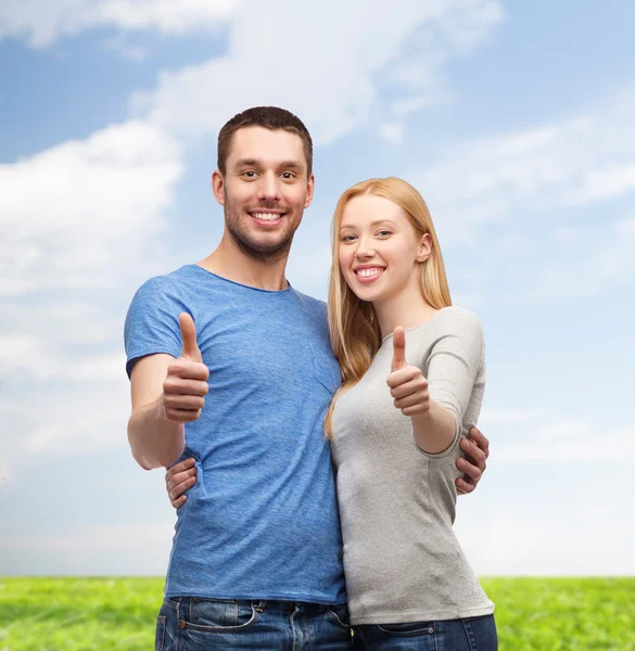 Smiling couple showing thumbs up — Stock Photo, Image