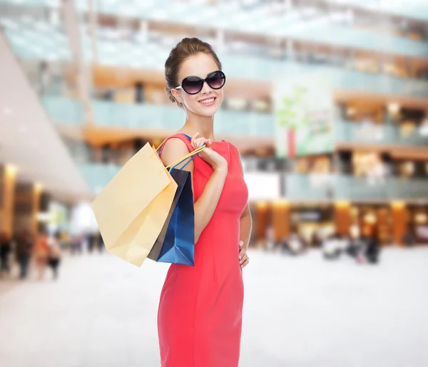Femme élégante souriante en robe avec des sacs à provisions — Photo