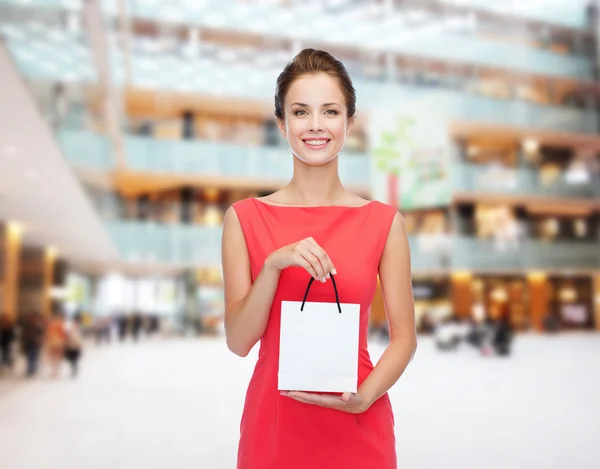 Donna elegante e sorridente in abito con shopping bag — Foto Stock