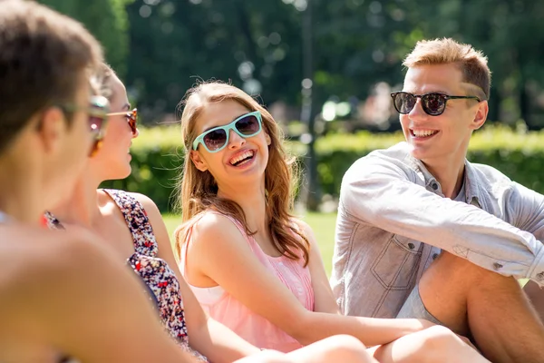 Grupo de amigos sonrientes al aire libre sentado en el parque — Foto de Stock