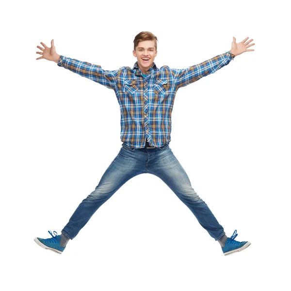 Smiling young man jumping in air — Stock Photo, Image