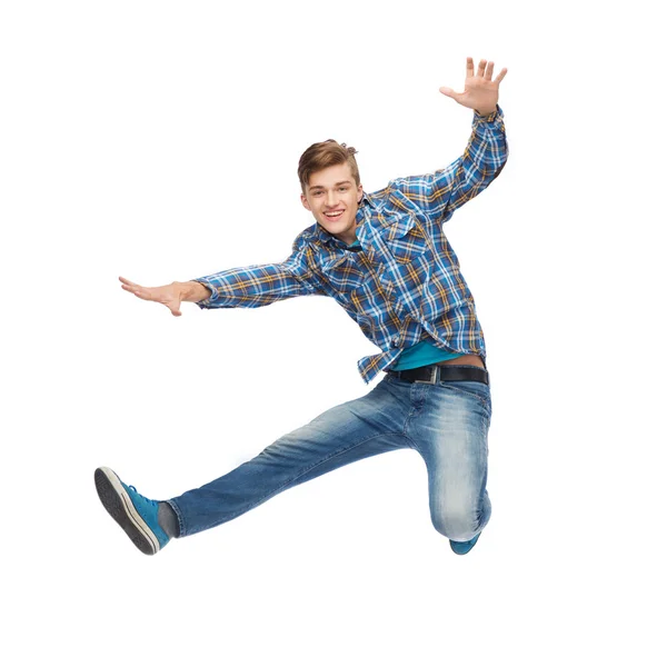 Улыбающийся молодой человек, прыгающий в воздух — стоковое фото