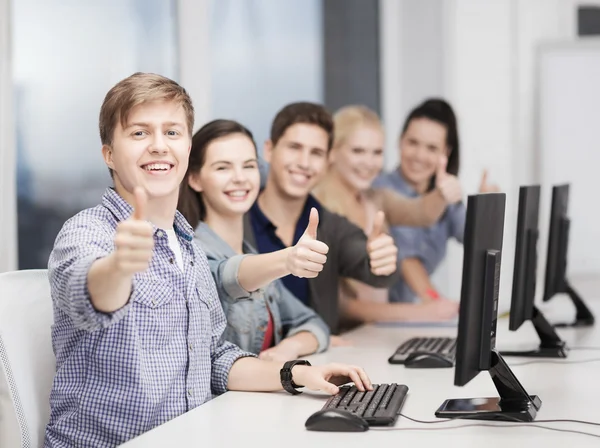 Estudiantes con monitor de computadora mostrando pulgares hacia arriba — Foto de Stock