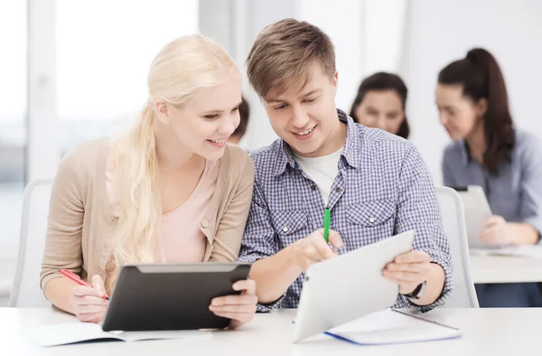 Två leende studenter med TabletPC och bärbara datorer — Stockfoto