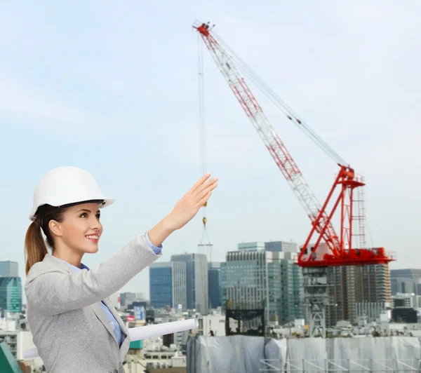 Smiling architect in helmet with blueprint — Stock Photo, Image