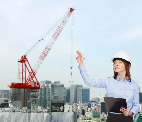 Mujer de negocios sonriente en casco con portapapeles —  Fotos de Stock