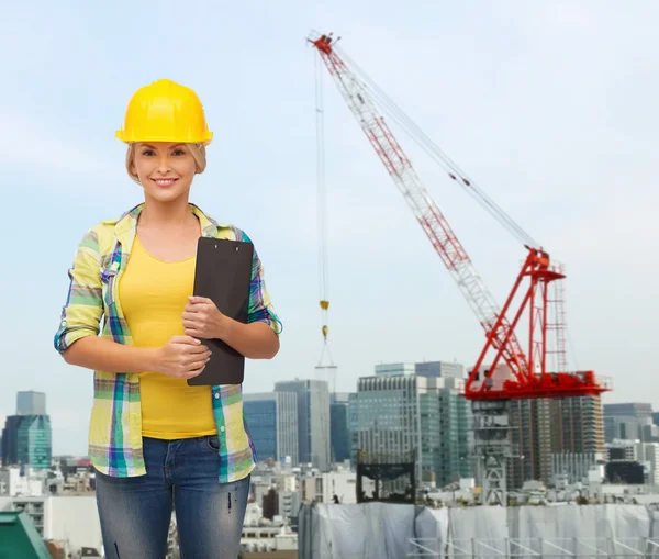 Donna sorridente in casco con appunti — Foto Stock