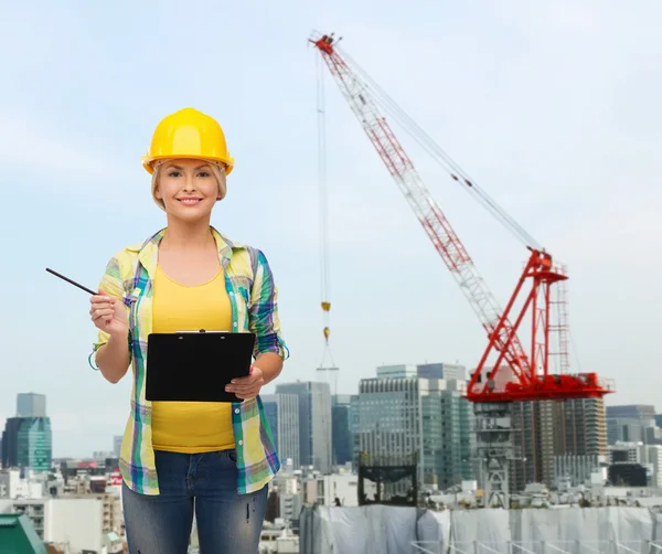 Donna sorridente in casco con appunti — Foto Stock