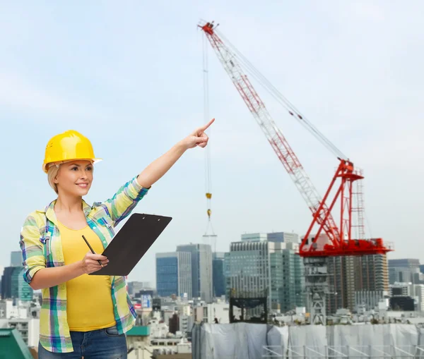 Donna sorridente in casco con appunti — Foto Stock