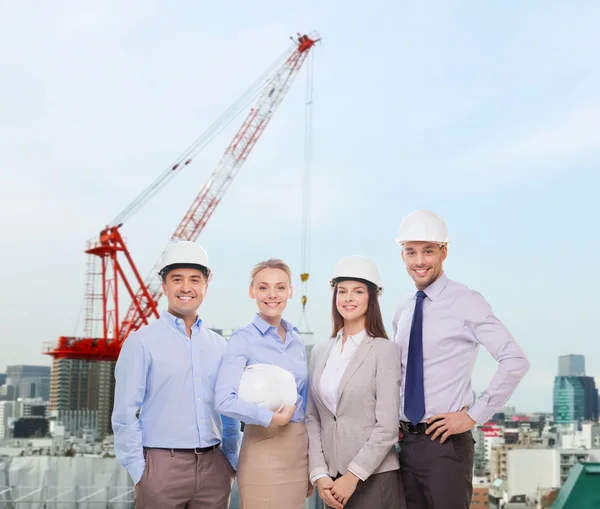 Grupp av leende affärsmän i vita hjälmar — Stockfoto