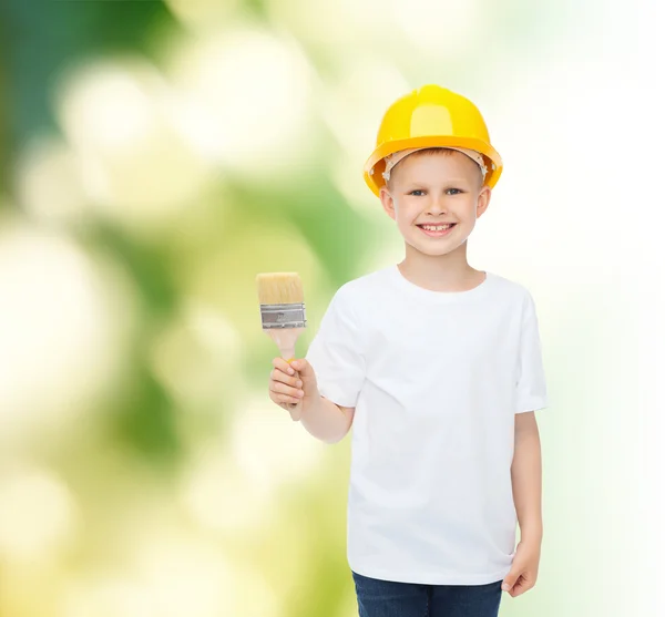 Smiling little boy in helmet with paint brush — Stock Photo, Image