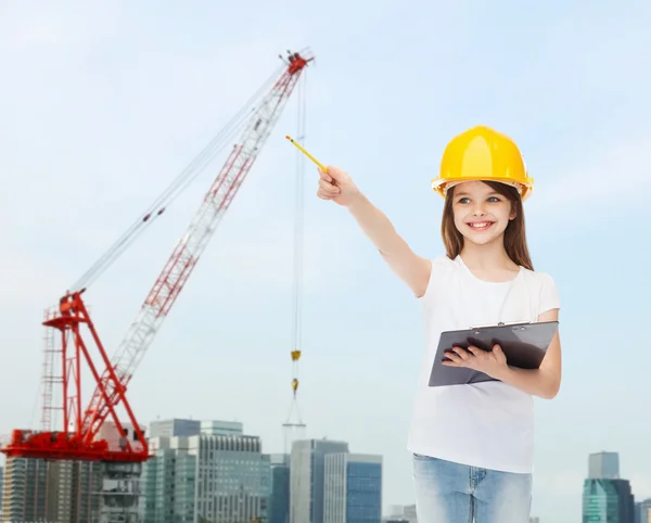 Sorridente bambina in hardhat con appunti — Foto Stock