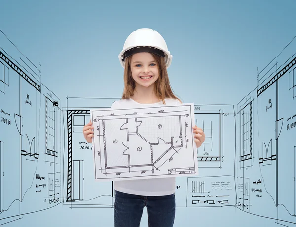 Smiling little girl in helmet showing blueprint — Stock Photo, Image