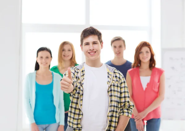 Mâle étudiant avec des camarades de classe montrant pouces vers le haut — Photo