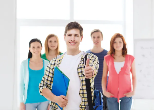 Mâle étudiant avec des camarades de classe montrant pouces vers le haut — Photo