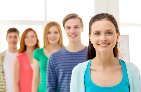 Studenti sorridenti con ragazza adolescente di fronte — Foto Stock