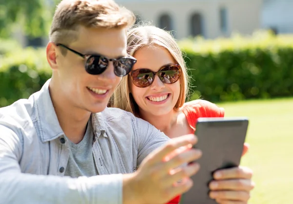 Sorridendo gli amici con computer pc tablet nel parco — Zdjęcie stockowe