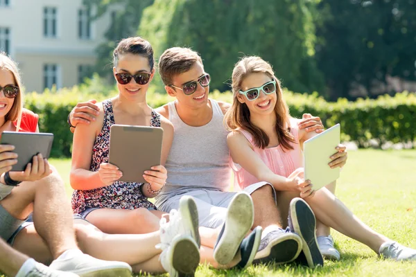 Amici sorridenti con i computer del pc della compressa nel parco — Foto Stock