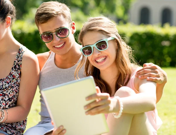 Smiling friends with tablet pc computers in park — Stock Photo, Image