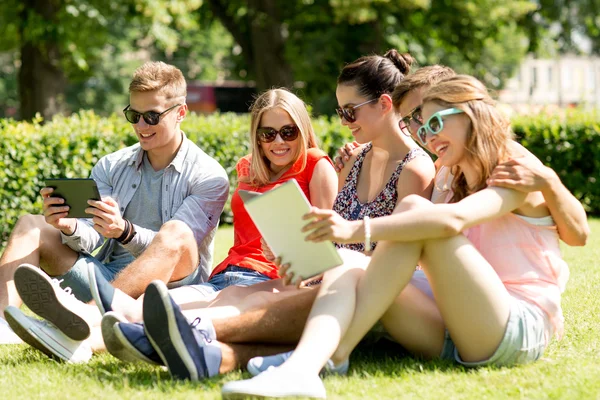 Sorridendo gli amici con computer pc tablet nel parco — Zdjęcie stockowe