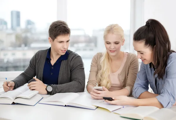 Lächelnde Schüler mit Notizbüchern in der Schule — Stockfoto