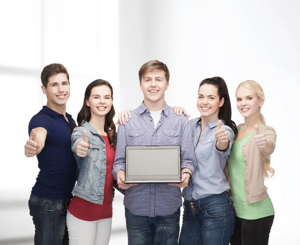 Estudantes sorridentes com computador portátil — Fotografia de Stock