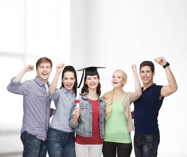 Группа стоящих улыбающихся студентов с дипломом — стоковое фото