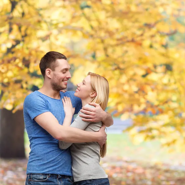 Lächelndes Paar, das sich umarmt und einander ansieht — Stockfoto