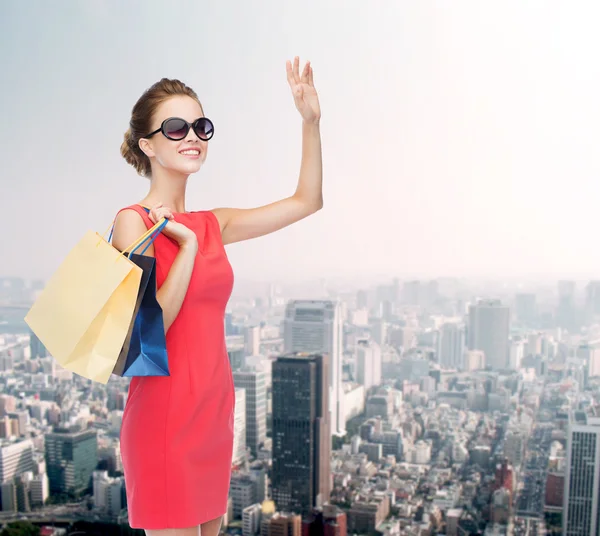 Mujer elegante sonriente en vestido con bolsas de compras — Foto de Stock