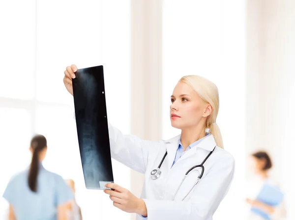 Médecin féminin sérieux qui regarde la radiographie — Photo