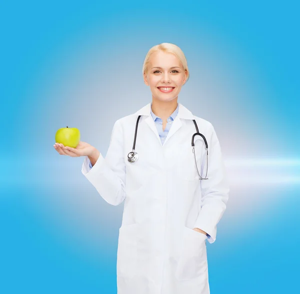 Lachende vrouwelijke arts met groene apple — Stockfoto