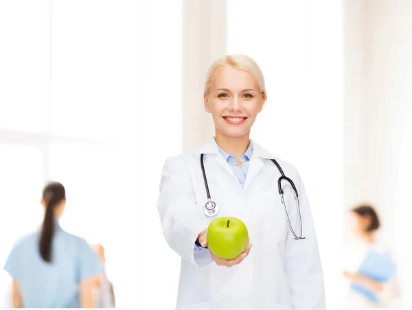 Yeşil elma ile gülümseyen kadın doktor — Stok fotoğraf