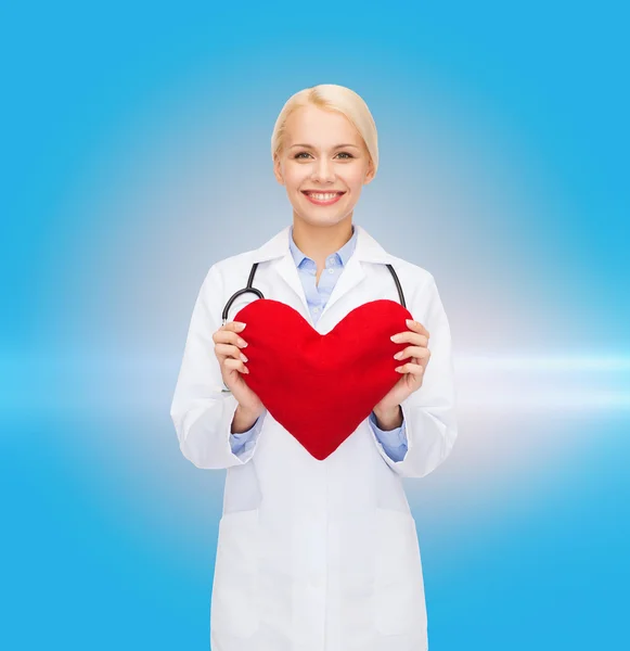 Femme médecin souriante avec cœur et stéthoscope — Photo