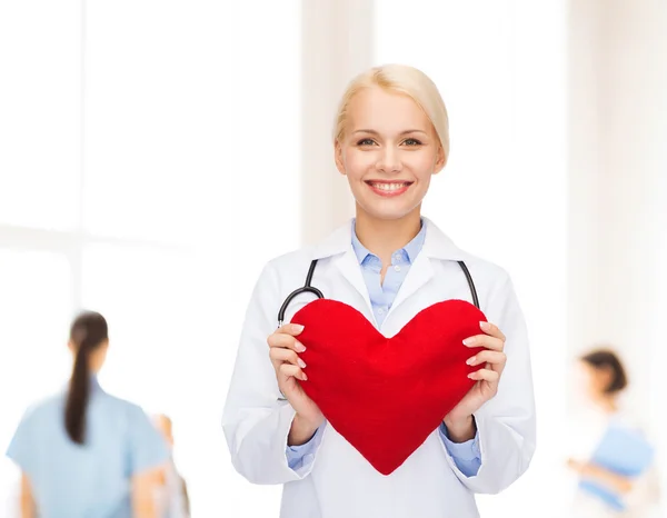 Doctora sonriente con corazón y estetoscopio — Foto de Stock