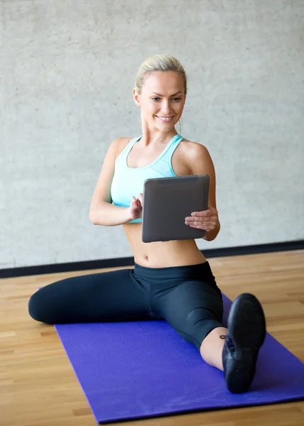 Uśmiechający się z komputera typu tablet w siłowni — Zdjęcie stockowe