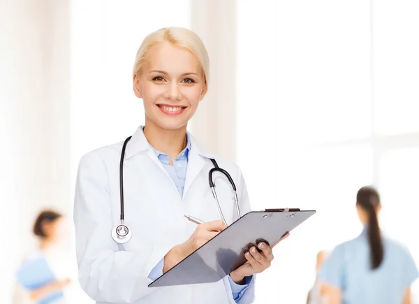 Smiling female doctor with clipboard Royalty Free Stock Images