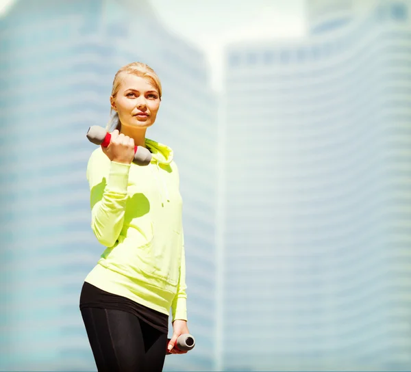 Sportieve vrouw met lichte halters buitenshuis — Stockfoto