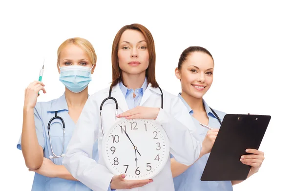 Doctora y enfermeras tranquilas con reloj de pared —  Fotos de Stock