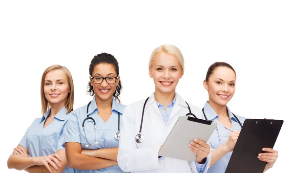 Smiling female doctor and nurses with tablet pc — Stock Photo, Image