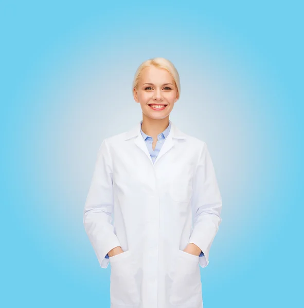 青い背景に笑みを浮かべて女性医師 — ストック写真