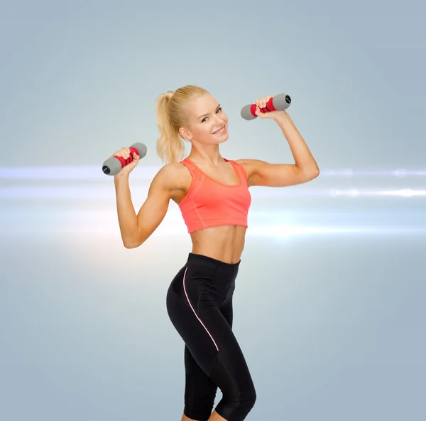 Smiling beautiful sporty woman with dumbbells — Stock Photo, Image