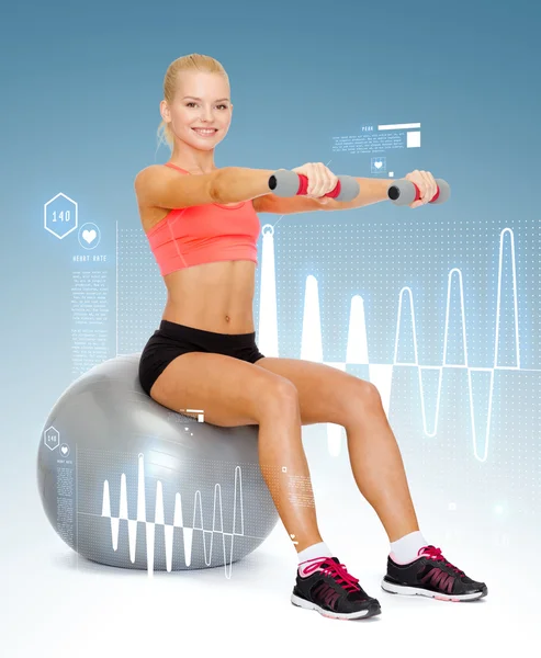 Kadın fitness topu üzerinde oturan dumbbells ile — Stok fotoğraf