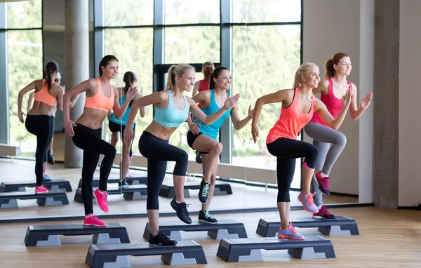 Gruppo di donne che si allenano con i steppers in palestra — Foto Stock