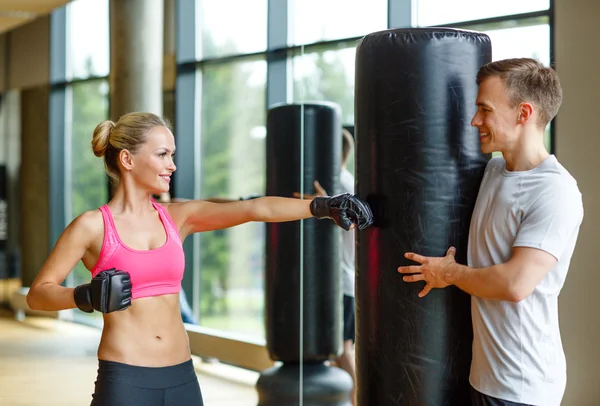 Leende kvinna med personlig tränare boxning i gym — Stockfoto
