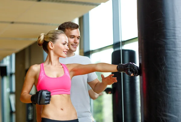 Sorrindo mulher com personal trainer boxe no ginásio — Fotografia de Stock