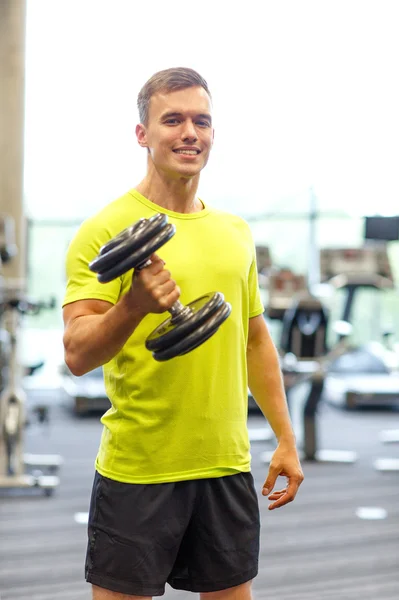 Hombre sonriente con mancuerna en el gimnasio — Foto de Stock