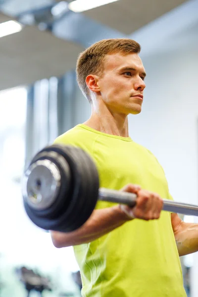 Hombre haciendo ejercicio con barra de pesas en gimnasio — Foto de Stock